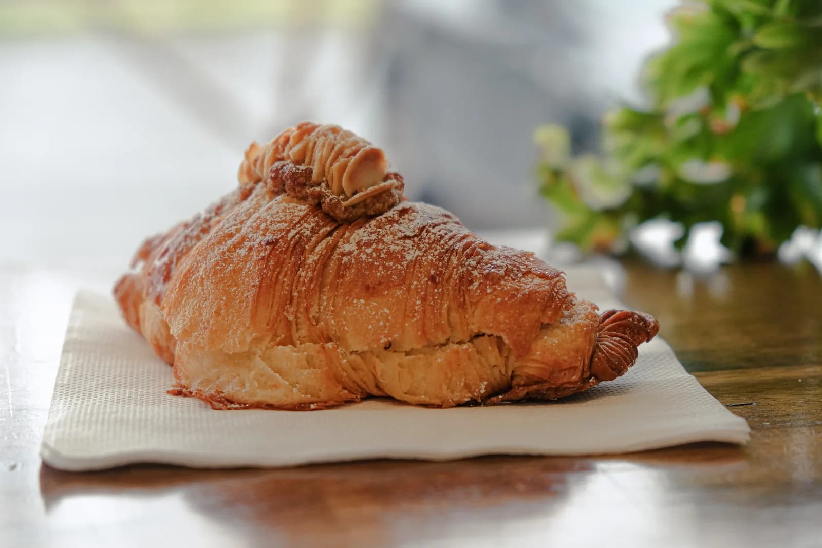 Close-up of a flaky pastry on a napkin on a café table